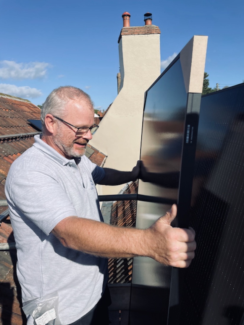 A CW Electrical engineer working on a solar installation on a roof